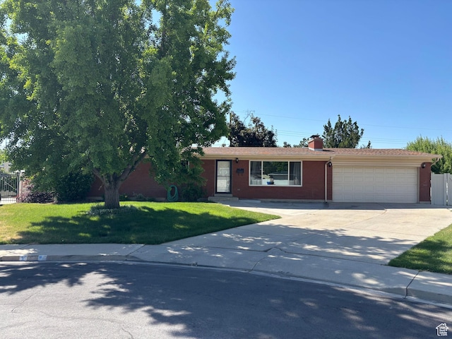 230 S 700 E, Orem, UT 84097 - view of front of home with an attached garage, concrete driveway, a chimney, and brick siding