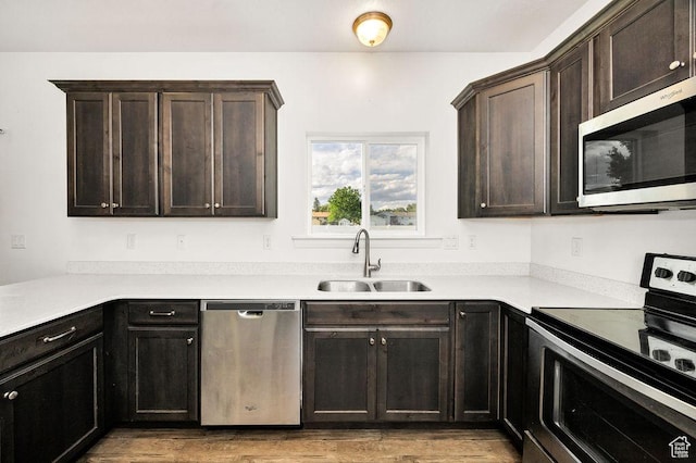 763 W 1060 S, Logan, UT 84321 - kitchen with stainless steel appliances, a sink, light wood-style floors, and dark brown cabinets