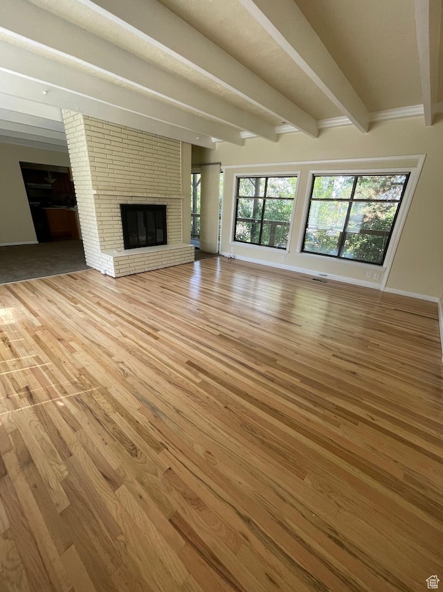 3599 E Oakview Dr, Millcreek, UT 84124 - unfurnished living room featuring beam ceiling, light wood-style floors, a fireplace, and plenty of natural light
