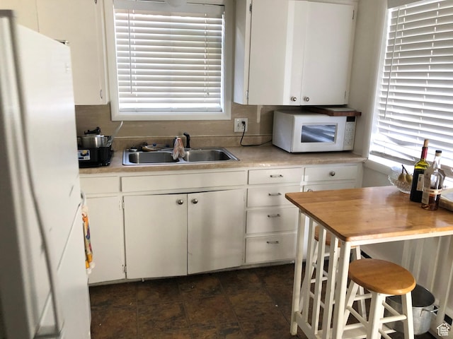 827 E 23rd St S, Ogden, UT 84401 - kitchen with white appliances, a sink, light countertops, and plenty of natural light