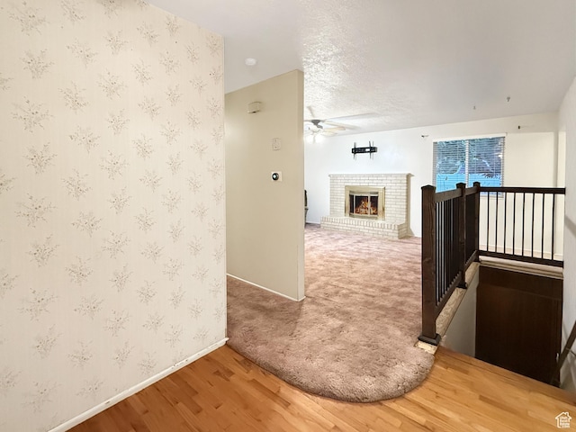 1066 Beecher Ave, Brigham City, UT 84302 - hallway with baseboards, wood finished floors, wallpapered walls, an upstairs landing, and a textured ceiling