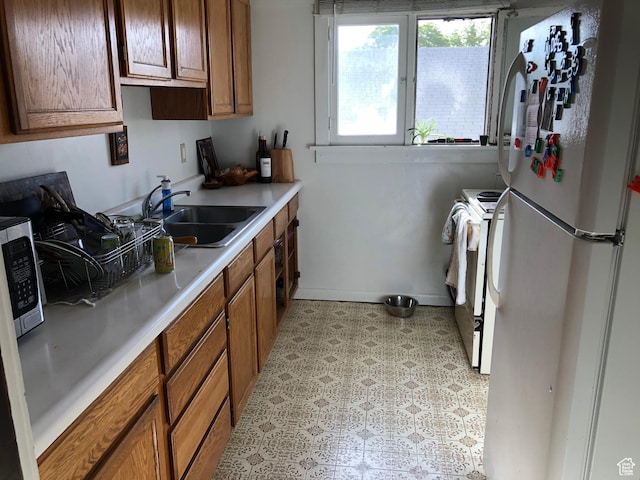 823 E 23rd St S, Ogden, UT 84401 - kitchen with white appliances, a sink, light flooring, and brown cabinetry