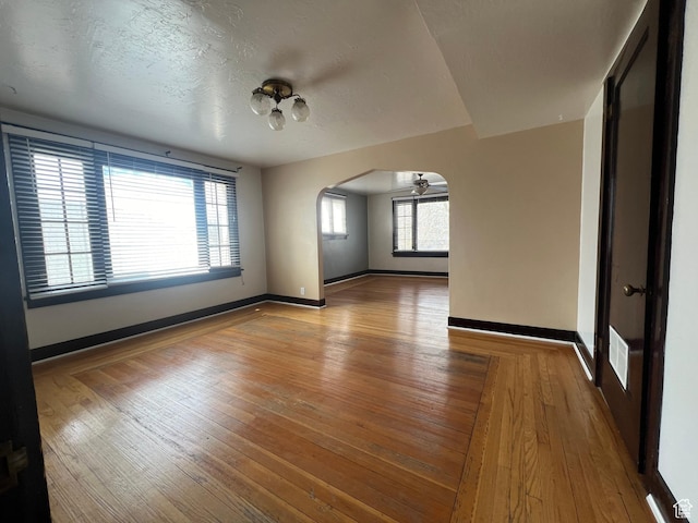 823 E 23rd St S, Ogden, UT 84401 - spare room with arched walkways, wood-type flooring, and baseboards