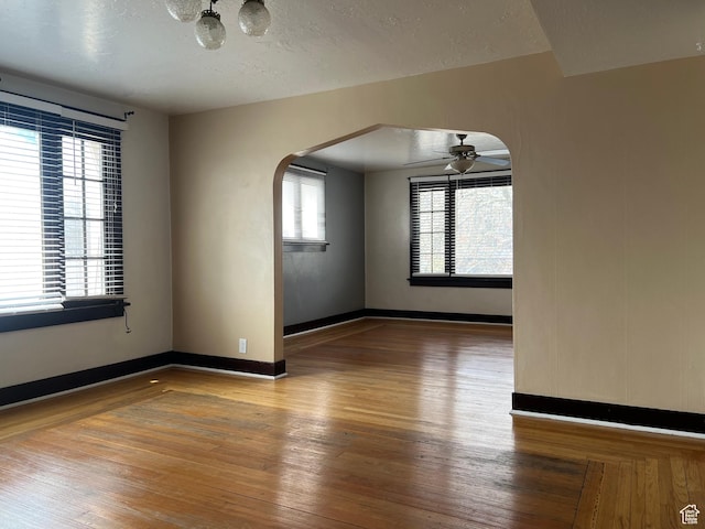 823 E 23rd St S, Ogden, UT 84401 - spare room featuring arched walkways, wood-type flooring, ceiling fan, baseboards, and a textured ceiling