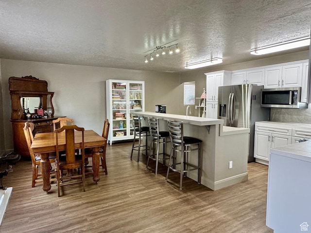 160 W 100 S, Fillmore, UT 84631 - dining area with a textured ceiling, light wood-type flooring, baseboards, and track lighting