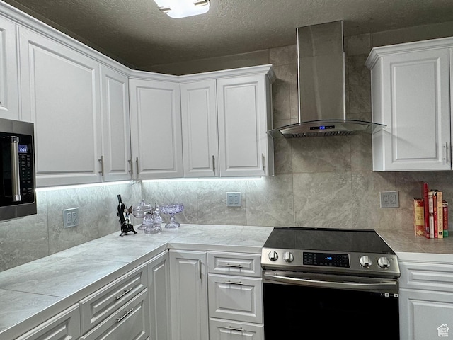 160 W 100 S, Fillmore, UT 84631 - kitchen with appliances with stainless steel finishes, wall chimney range hood, white cabinets, light countertops, and a textured ceiling