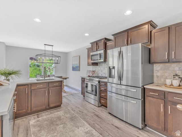 2286 E Deer Park Ln, Draper, UT 84020 - kitchen featuring stainless steel appliances, a sink, light wood-style flooring, decorative backsplash, and recessed lighting