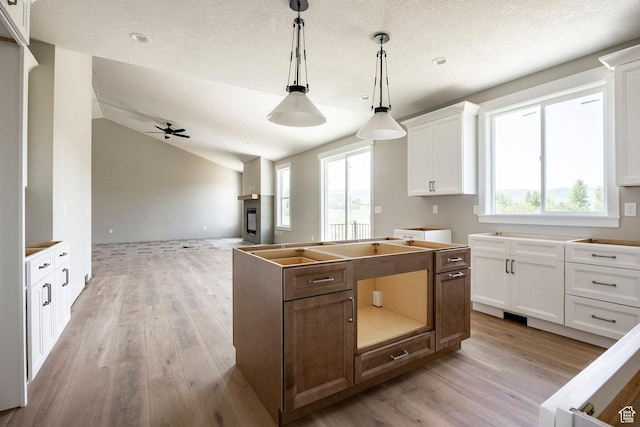 1928 E 540 S, Heber City, UT 84032 - kitchen featuring light wood-style floors, open floor plan, a center island, white cabinetry, and decorative light fixtures