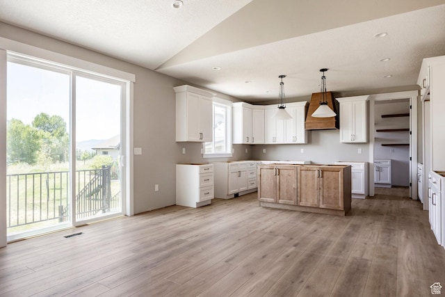 1928 E 540 S, Heber City, UT 84032 - kitchen with light wood finished floors, vaulted ceiling, custom exhaust hood, a kitchen island, and hanging light fixtures