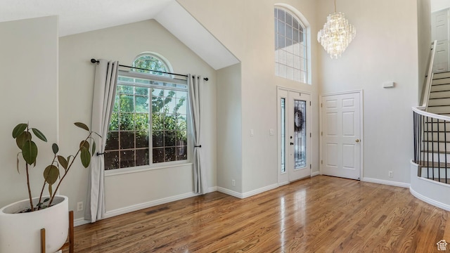 9677 S Iron Gate Rd, South Jordan, UT 84095 - foyer with wood finished floors, high vaulted ceiling, stairway, a chandelier, and baseboards