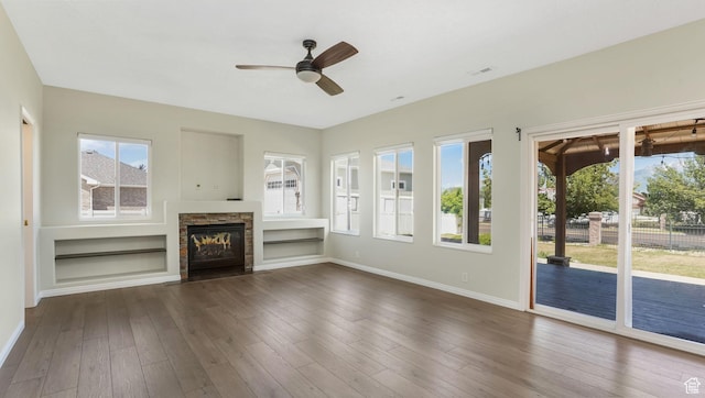 9677 S Iron Gate Rd, South Jordan, UT 84095 - unfurnished living room featuring a ceiling fan, a stone fireplace, healthy amount of natural light, and baseboards