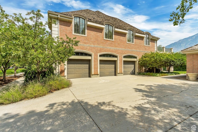 4234 N Vintage Cir, Provo, UT 84604 - french country style house featuring driveway, brick siding, a garage, and a mountain view