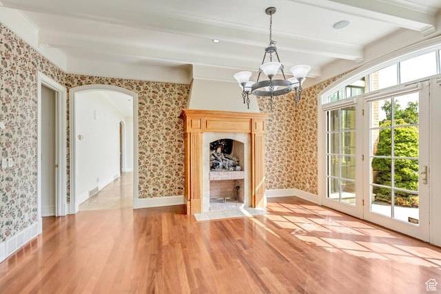 4234 N Vintage Cir, Provo, UT 84604 - unfurnished dining area featuring wallpapered walls, a chandelier, beam ceiling, arched walkways, and light wood-type flooring