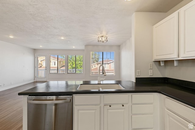 1389 S Alpine Way, Provo, UT 84606 - kitchen featuring stainless steel dishwasher, a sink, a peninsula, dark countertops, and white cabinetry