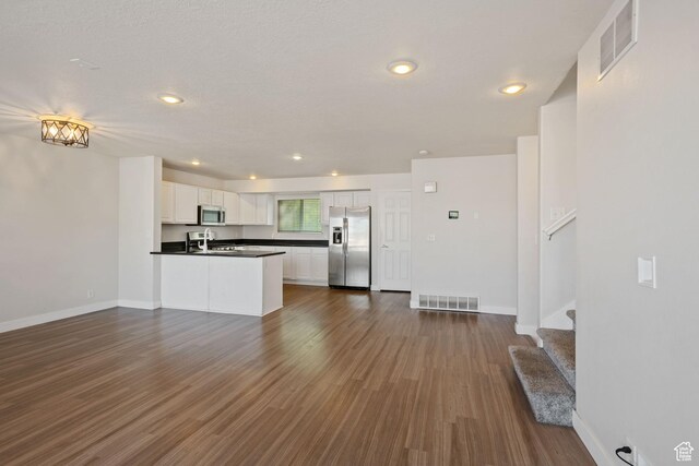 1389 S Alpine Way, Provo, UT 84606 - kitchen featuring stainless steel appliances, dark countertops, open floor plan, white cabinetry, and dark wood finished floors