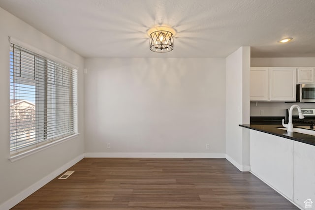 1389 S Alpine Way, Provo, UT 84606 - unfurnished dining area with dark wood finished floors, baseboards, a sink, recessed lighting, and a textured ceiling