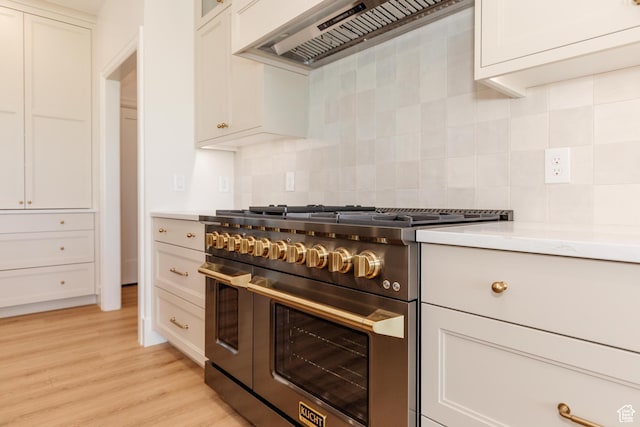 435 E 200 N, Millville, UT 84326 - kitchen with double oven range, custom exhaust hood, light countertops, backsplash, and light wood-style floors