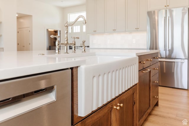 435 E 200 N, Millville, UT 84326 - kitchen with stainless steel appliances, light wood finished floors, brown cabinetry, and light countertops