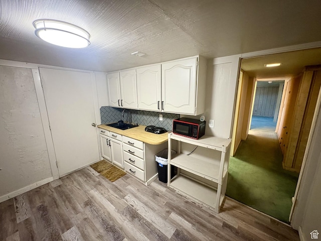 391 N 100 W, Delta, UT 84624 - kitchen with black microwave, white cabinetry, light wood-style flooring, light countertops, and a sink