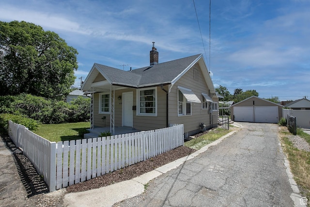 1438 E Woodland Ave S, Millcreek, UT 84106 - bungalow-style home featuring covered porch, a detached garage, an outbuilding, a chimney, and a shingled roof