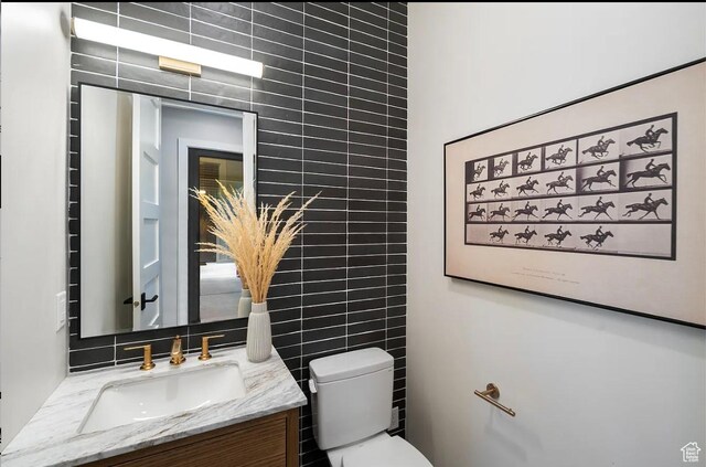 1040 S Summit Creek Dr, Woodland Hills, UT 84653 - half bathroom featuring tile walls, vanity, toilet, and tasteful backsplash