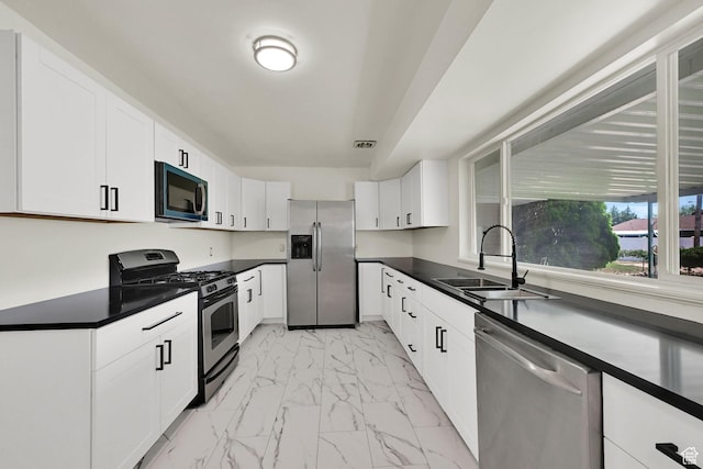 5151 S 2275 W, Roy, UT 84067 - kitchen featuring stainless steel appliances, a sink, light marble finish floors, dark countertops, and white cabinetry