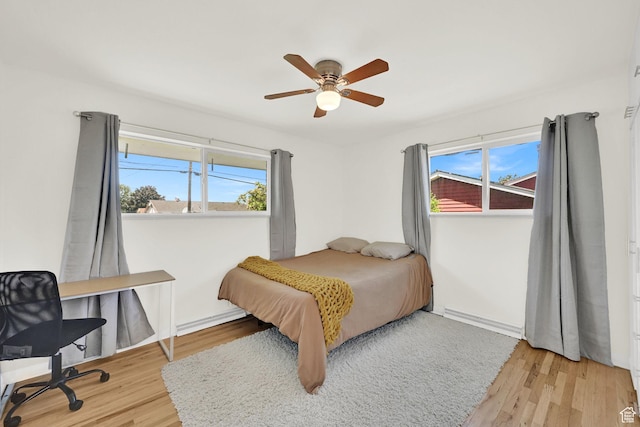 5151 S 2275 W, Roy, UT 84067 - bedroom featuring a baseboard heating unit, light wood finished floors, ceiling fan, and a desk