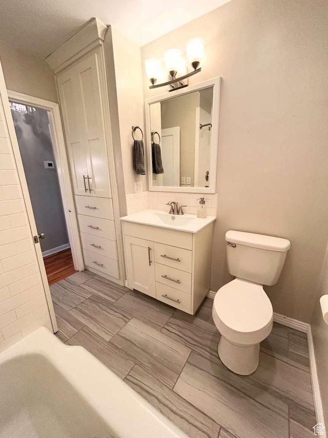 2326 E 1700 S, Salt Lake City, UT 84108 - bathroom with toilet, vanity, a chandelier, and backsplash