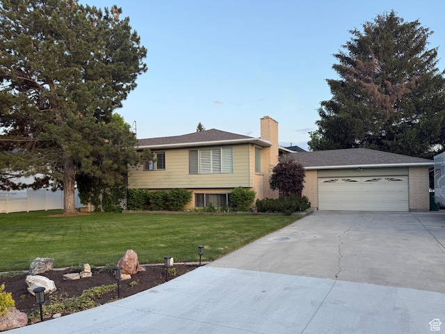6209 W 9600 N, Highland, UT 84003 - split level home featuring a front yard, driveway, a chimney, a garage, and brick siding