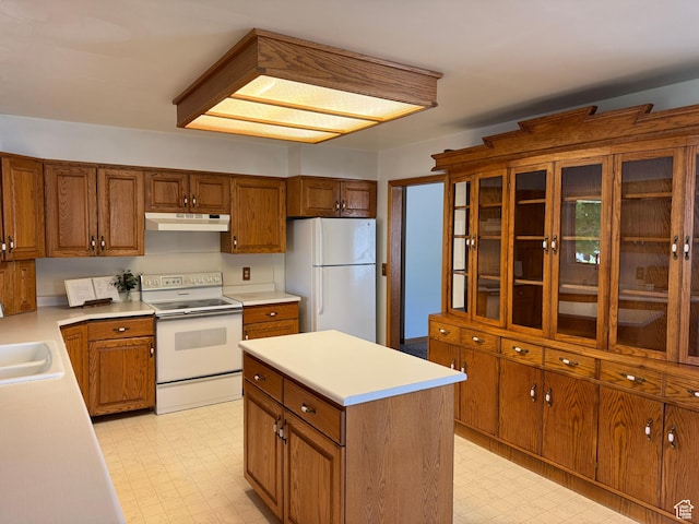 6209 W 9600 N, Highland, UT 84003 - kitchen with white appliances, under cabinet range hood, light flooring, and brown cabinetry