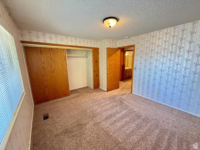 6209 W 9600 N, Highland, UT 84003 - unfurnished bedroom featuring wallpapered walls, a closet, carpet floors, and a textured ceiling