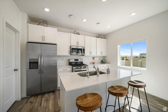 3493 N Sparrow Ln, Eagle Mountain, UT 84005 - kitchen featuring stainless steel appliances, dark wood-type flooring, white cabinetry, a center island with sink, and recessed lighting