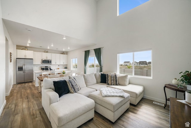 3493 N Sparrow Ln, Eagle Mountain, UT 84005 - living area with light wood-style flooring, healthy amount of natural light, recessed lighting, and a towering ceiling
