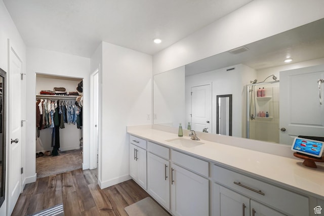 3493 N Sparrow Ln, Eagle Mountain, UT 84005 - full bath featuring wood finished floors, a walk in closet, vanity, a shower stall, and recessed lighting