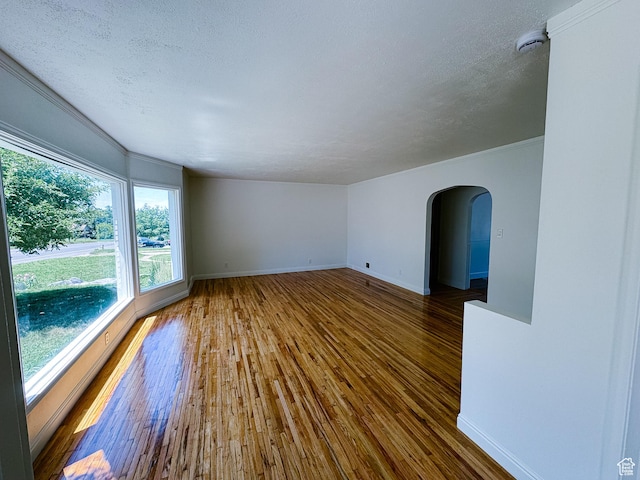 1516 E 36th, Ogden, UT 84403 - unfurnished room featuring arched walkways, wood-type flooring, a smoke detector, baseboards, and a textured ceiling