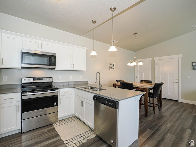 14654 S Bloom Dr W Unit K 304, Herriman, UT 84096 - kitchen with stainless steel appliances, a sink, dark wood finished floors, white cabinets, and vaulted ceiling