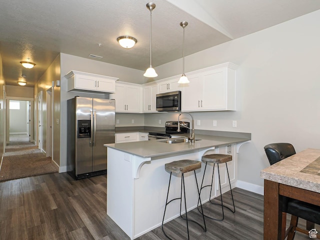 14654 S Bloom Dr W Unit K 304, Herriman, UT 84096 - kitchen featuring appliances with stainless steel finishes, a sink, a peninsula, dark wood finished floors, and baseboards
