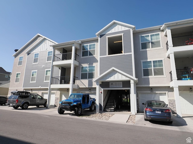 14654 S Bloom Dr W Unit K 304, Herriman, UT 84096 - view of building exterior featuring an attached garage, stairway, and driveway