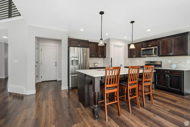 12364 S Boggs Way, Herriman, UT 84096 - kitchen featuring appliances with stainless steel finishes, light countertops, dark wood finished floors, dark brown cabinets, and recessed lighting
