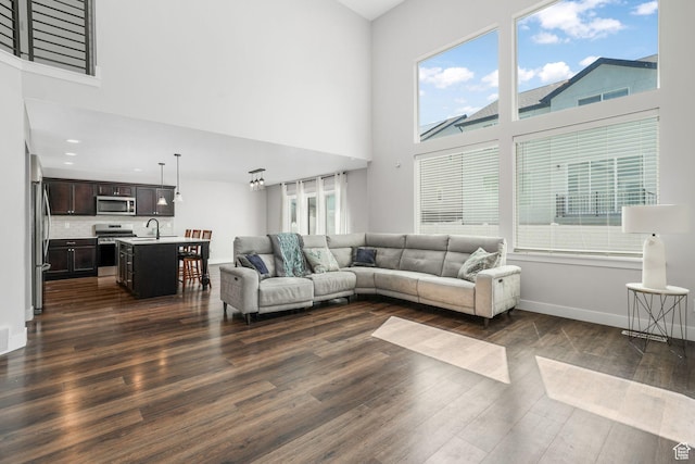 12364 S Boggs Way, Herriman, UT 84096 - living area with a high ceiling, dark wood finished floors, and baseboards