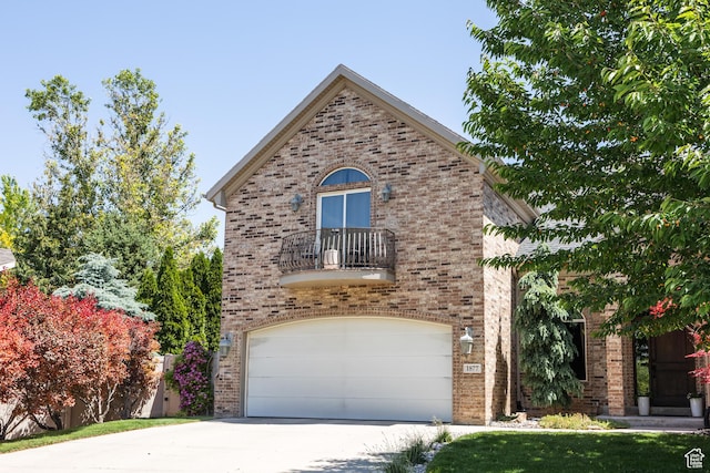 1877 E 3990 S, Holladay, UT 84124 - view of front facade featuring a balcony, brick siding, concrete driveway, and a garage