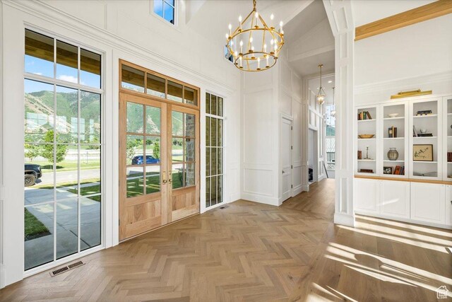 478 S Maple Lakes Dr, Mapleton, UT 84664 - entryway featuring french doors, a decorative wall, a high ceiling, and a chandelier