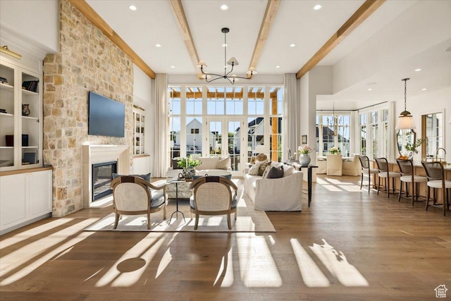 478 S Maple Lakes Dr, Mapleton, UT 84664 - living area featuring wood finished floors, beamed ceiling, a chandelier, a large fireplace, and a towering ceiling