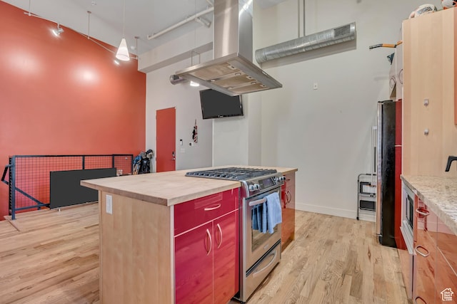 342 W 200 S Unit 107, Salt Lake City, UT 84101 - kitchen with stainless steel gas range oven, island exhaust hood, light wood-type flooring, a high ceiling, and freestanding refrigerator