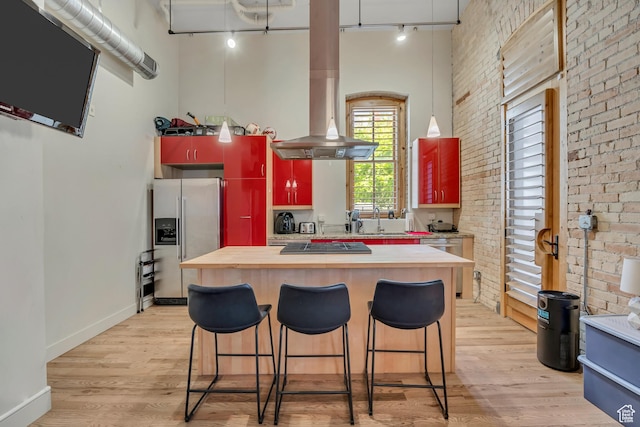 342 W 200 S Unit 107, Salt Lake City, UT 84101 - kitchen with appliances with stainless steel finishes, rail lighting, brick wall, light wood-style flooring, and a center island