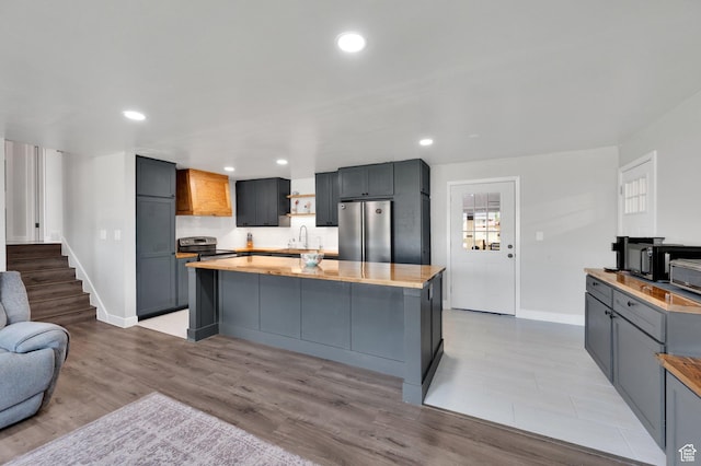 1701 N Forbes Ave W, Layton, UT 84041 - kitchen featuring appliances with stainless steel finishes, a sink, baseboards, light wood-style flooring, and a center island