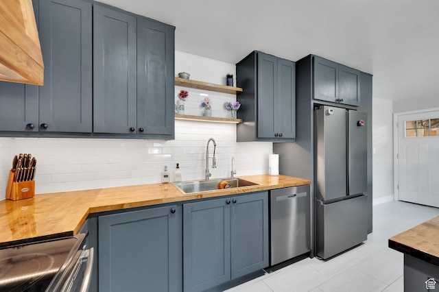 1701 N Forbes Ave W, Layton, UT 84041 - kitchen featuring stainless steel appliances, a sink, wood counters, decorative backsplash, and light tile patterned flooring