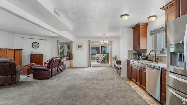 7505 S Creek Rd E, Cottonwood Heights, UT 84093 - kitchen featuring stainless steel appliances, a sink, a chandelier, open floor plan, and light colored carpet