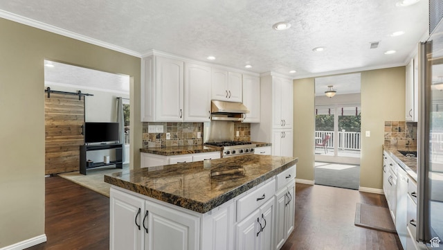 7505 S Creek Rd E, Cottonwood Heights, UT 84093 - kitchen with under cabinet range hood, dark wood-style floors, backsplash, a center island, and ornamental molding
