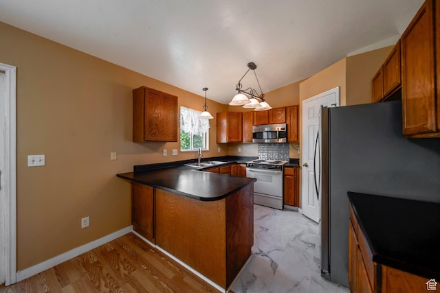 4213 S 2850 W, Roy, UT 84067 - kitchen with appliances with stainless steel finishes, a peninsula, a sink, dark countertops, and brown cabinetry